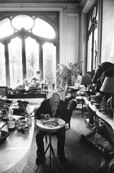 毕加索在戛纳家中餐厅进行创作，在陶器上作画，1957年